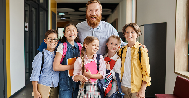 Teacher mentoring students in a school hallway